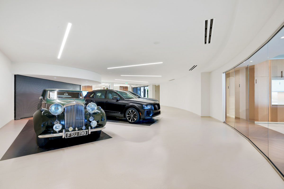 Picture of three cars inside of a Bentley Residences garage. 