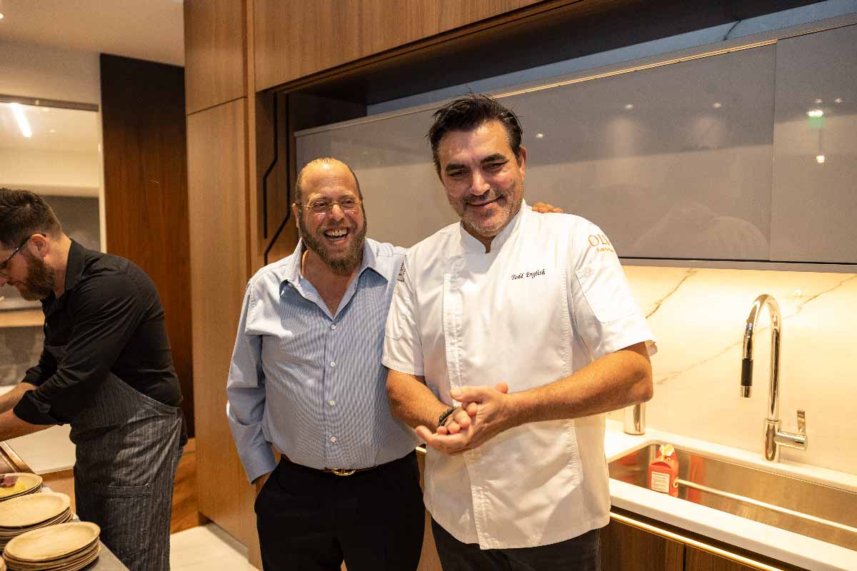 Left-to-right: Gil Dezer and Chef Todd English smiling at the camera in Bentley Residences. Gil has his hand on Todd's shoulder. 