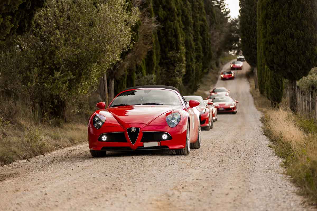 Several red cars racing down a dirt track at the Four Seasons Napa