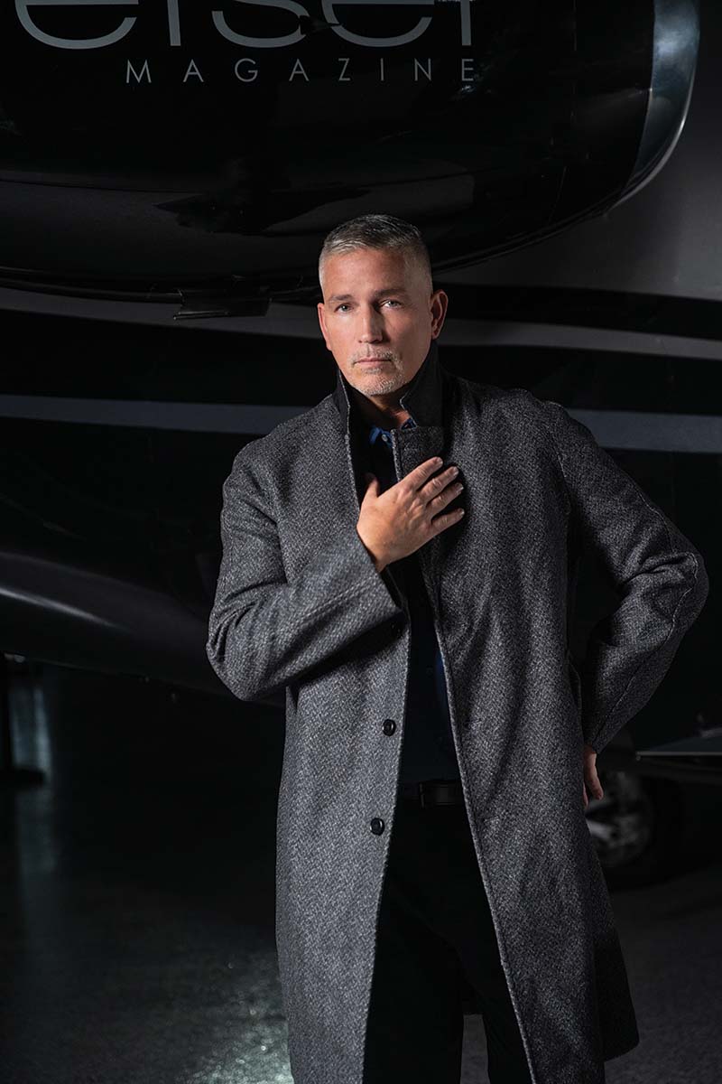 Jim Caviezel standing in front of Jetset's plane with his hand over his heart. 