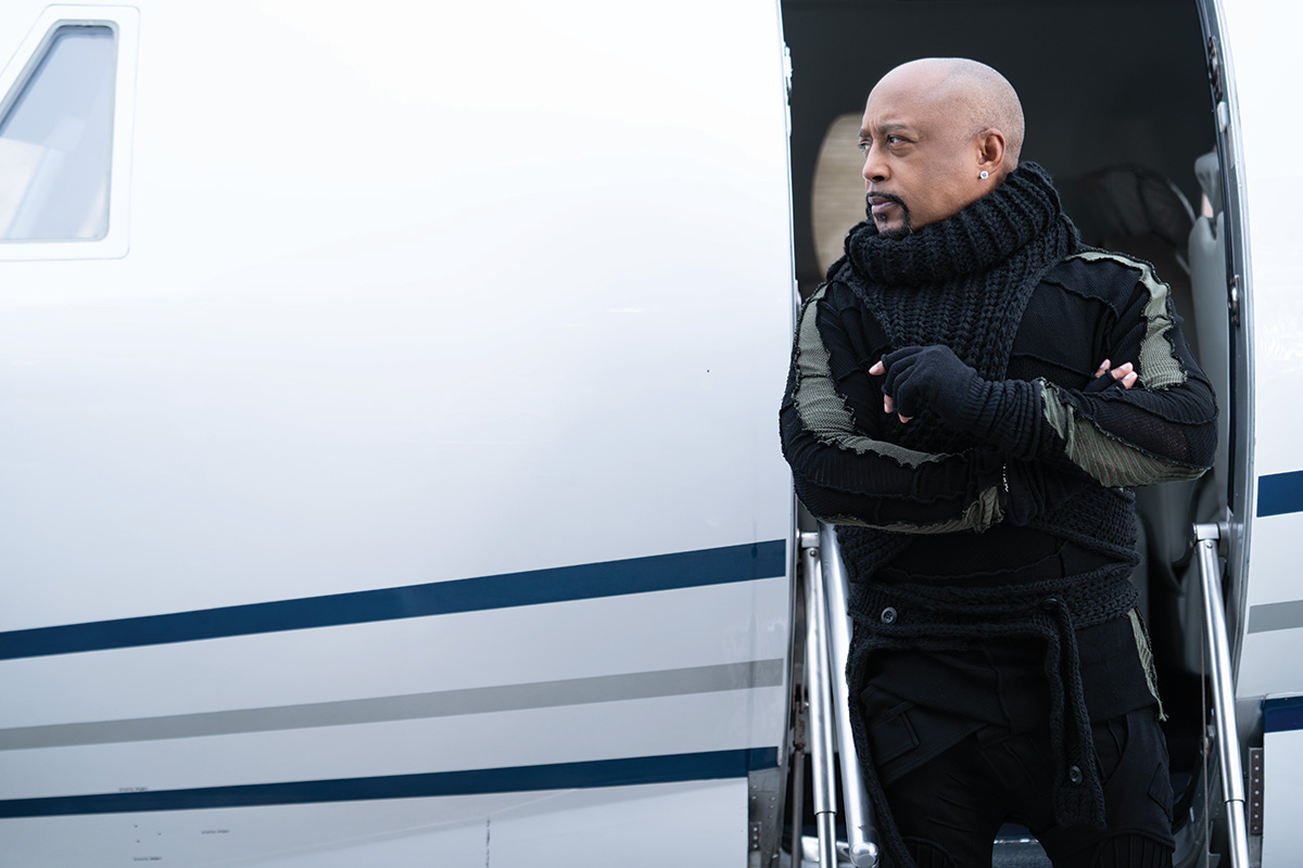 Daymond John in a sweater, posing in front of a 2002 CESSNA 560XL
