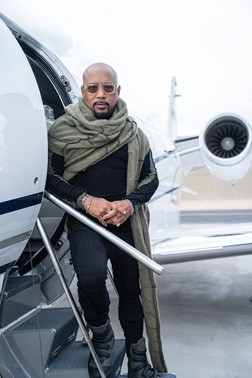 Daymond John in a scarf, posing on the stairs of a 2002 CESSNA 560XL